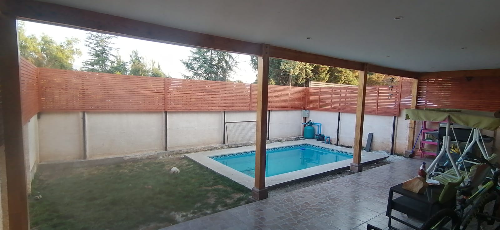 Pérgola de madera y hierro corta muro